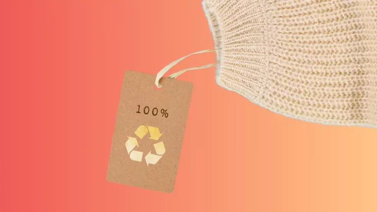 a beige-colored tag with "100%" and a recycling symbol printed on it, suggesting the item is made from 100% recyclable materials.
